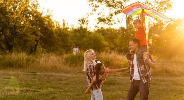 Sahada gün batımında oynayan mutlu bir aile.