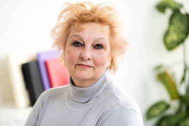 Fotoğraf makinesine bakıp konuşan olgun bir kadın. Büyükannem internetten akrabasıyla sohbet ediyor. Video görüşmesi yapıyor. Orta yaşlı blogcu vlog 'u kaydediyor.