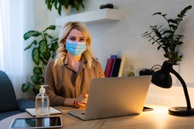 Bir salgın sırasında kendinizi koruyun, salgın hastalık. Ofisteki genç kadın, dezenfektan.