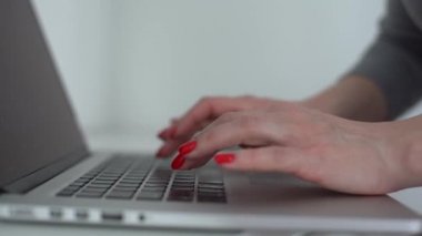 Beyaz klavye tuşlarına basan ve kalem tutan kadın ellerinin yakın çekimi.