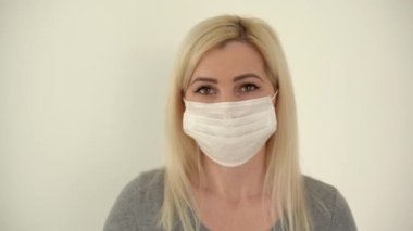 İş görüşmesi. Kameraya konuşan genç bir kadının portresi. Kapalı alanda maske takıyor..