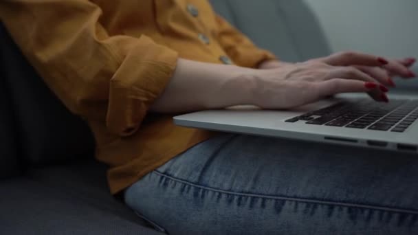 Ελκυστική νεαρή γυναίκα απολαμβάνοντας αυτό που κάνει καθώς εργάζεται στον υπολογιστή της στο όμορφο διαμέρισμά της — Αρχείο Βίντεο