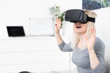 Sanal gerçeklik kulaklığı kullanan kadın.