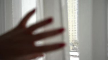 Camdan bakan genç bir kadın. Kendine güvenen mutlu bayan güzel manzaranın ve evde hayal kurmanın tadını çıkarıyor. Gülümseyen kız, düşüncelere dalmış. Huzurlu bir sabah geçiriyor.