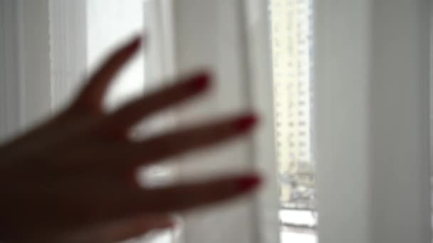 Mujer joven abriendo la cortina mirando por la ventana. Feliz dama confiada disfrutando de una hermosa vista y soñando en casa. Sonriente chica contemplando la sensación de esperanza pacífica mañana de pie en el apartamento — Vídeo de stock