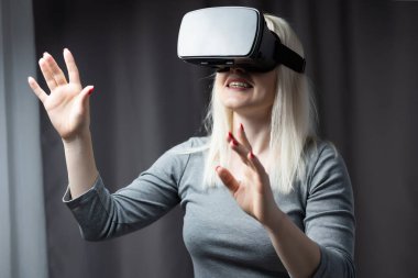 Çekici genç bir kadın. VR kulaklığını ayarlıyor ve gülümsüyor.