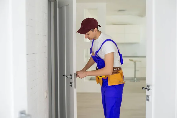 Der Meister montiert ein Türschloss in der Eingangstür, Metalltüren mit Polymerbeschichtung — Stockfoto