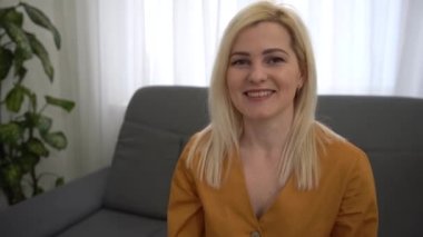 Sarı kazak giyen, kameraya bakan ve gülümseyen güzel bir genç kadının portresi. Parlak Çeşitli Ofiste Çalışan Başarılı Kadın