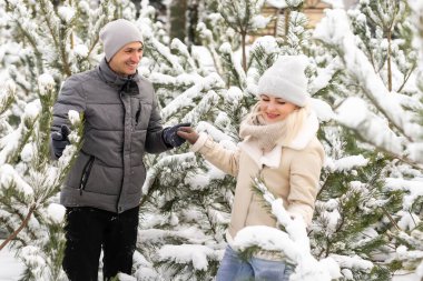 Karlı kış ormanlarında yürüyen, Noel tatilini birlikte geçiren mutlu bir çift. Açık havada mevsimlik aktiviteler. Yaşam biçimi