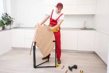 Genç adam mutfak mobilyalarını monte ediyor..