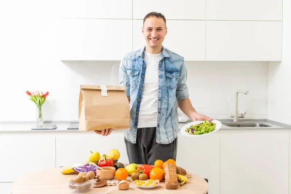 Delivery Concept - Handsome Cacasian delivery man carrying package box of grocery food and drink from store. Copy Space.