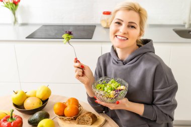 Güzel genç bayan mutfakta sebze salatası hazırlıyor. Evde Pişirme