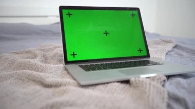 Yatağında yeşil ekran olan bir dizüstü bilgisayar. Uzak sanal uzaklık öğrenme video sohbetleri için kavram.