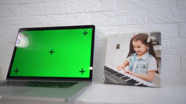 Ordenador portátil de pantalla verde sentado en un escritorio de trabajo en casa junto a una lámpara de escritorio. — Vídeos de Stock