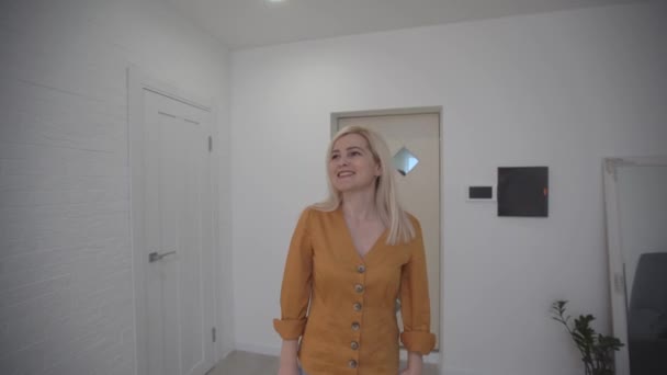 Uma mulher a entrar num apartamento novo. Apartamento vazio.. — Vídeo de Stock