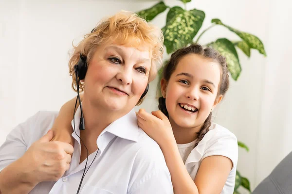 Nieta y abuela escuchan música mp3 auriculares juntos sonriendo — Foto de Stock