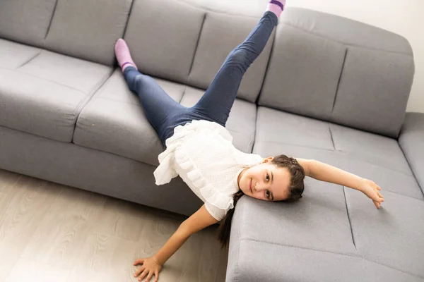 Positivt leende blond tonåring flicka liggande på en soffa — Stockfoto