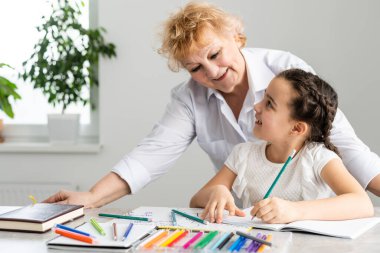 Büyükanne ve küçük kız ödev yapıyor.