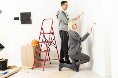 Mutlu çift dairelerini boyarken eğleniyor.