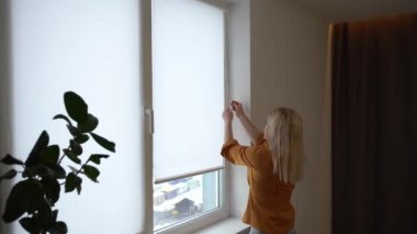 İş kadını otel odasındaki perdeleri açıyor. Yeni bir güne bakıyor. Başarılı, bağımsız bir kadın bulutlu bir sabahta planlama yapıyor.
