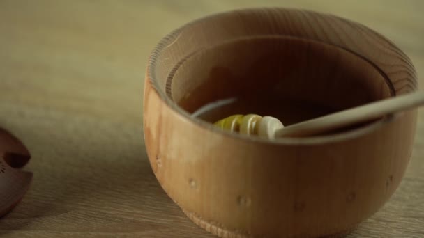 Μέλι στάζει, ρίχνει από το μέλι dipper σε ξύλινο μπολ. Κοντινό πλάνο. Υγιή βιολογικά Πυκνό μέλι εμβάπτιση από την ξύλινη κουτάλα μελιού, closeup. Βίντεο 4K UHD. Αργή κίνηση — Αρχείο Βίντεο