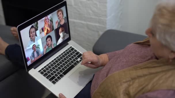 Ältere Frau telefoniert am Laptop, winkt dem Bildschirm zu, chattet mit Kindern, freier Platz — Stockvideo
