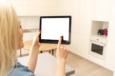 Akıllı ev kavramı. Genç bir kadın tablet üzerinde akıllı ev uygulaması kullanıyor.