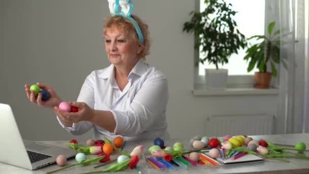 La donna anziana soffre di colore giallo uovo di Pasqua. Famiglia che si prepara per Pasqua. Mani in primo piano con uovo — Video Stock