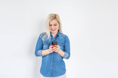 Beyaz arka planda izole edilmiş akıllı bir telefonu kullanan ve okuyan güzel bir kadın.