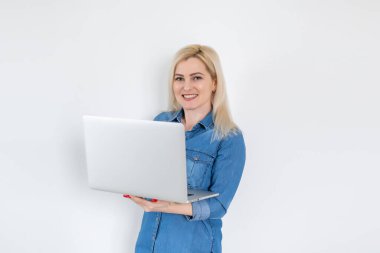 Beyaz arka planda dizüstü bilgisayar tutan genç ve güzel bir iş kadınının portresi.