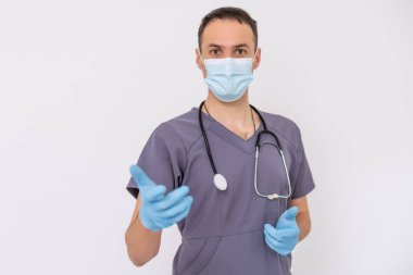 Koruyucu maskeli ve eldivenli teslimatçı, bir binanın önünde poşet dolusu erzak..