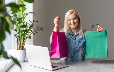 İşine odaklan. Akıllı, rahat giyinen, kendine güveni tam genç bir kadın kreatif ofis veya kafenin penceresinin yanında otururken dizüstü bilgisayarla çalışıyor.