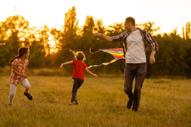 Babası küçük kızıyla birlikte bir uçurtmayı tarlaya bıraktı.