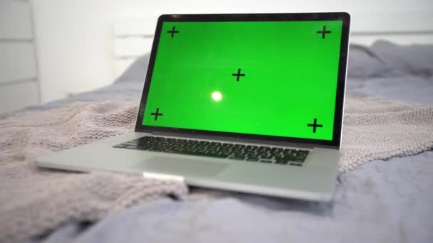 Laptop computer met groen scherm op een bed. Concept voor remote virtuele afstandsonderwijs video chats. — Stockvideo