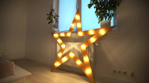 Close-up van enkele elektrisch verlichte ster met warm gele lichten. Sterrenverlichting decoraties thuis, Kerstmis en Nieuwjaar feest thuis — Stockvideo