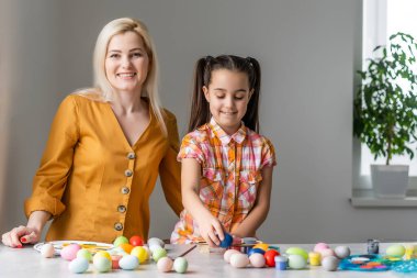 Anne ve kızı birlikte kutlama konseptinde oturup tebrik kartı okuyorlar.