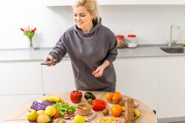 Akıllı telefonunda kalori sayacı uygulaması kullanan bir kadın