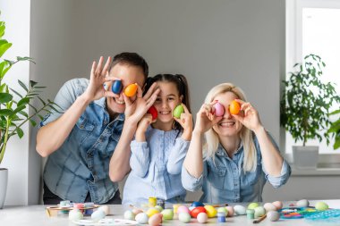 Paskalya yumurtalı mutlu bir aile. Mutlu aile Paskalya için hazırlanıyor.