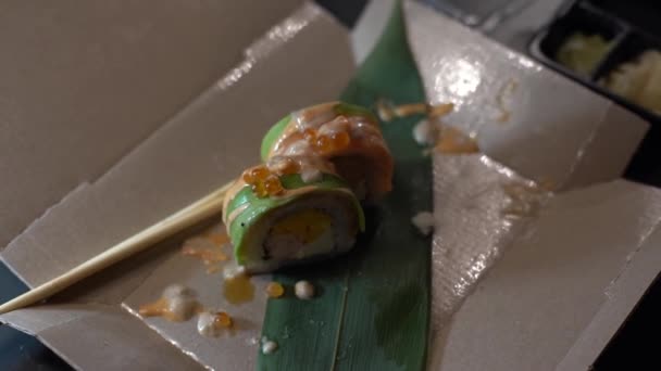 Hermosa joven comiendo sushi roll. Mujer comiendo sushi con palillos — Vídeo de stock