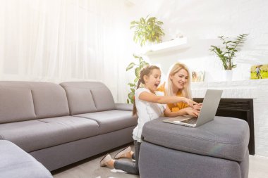 Coronavirus salgını. Kilitlenme ve okul kapanır. Anne, kızının evde online ders çalışmasına yardım ediyor. COVID-19 salgını, çocuklar ve öğretmenler çevrimiçi öğrenim.