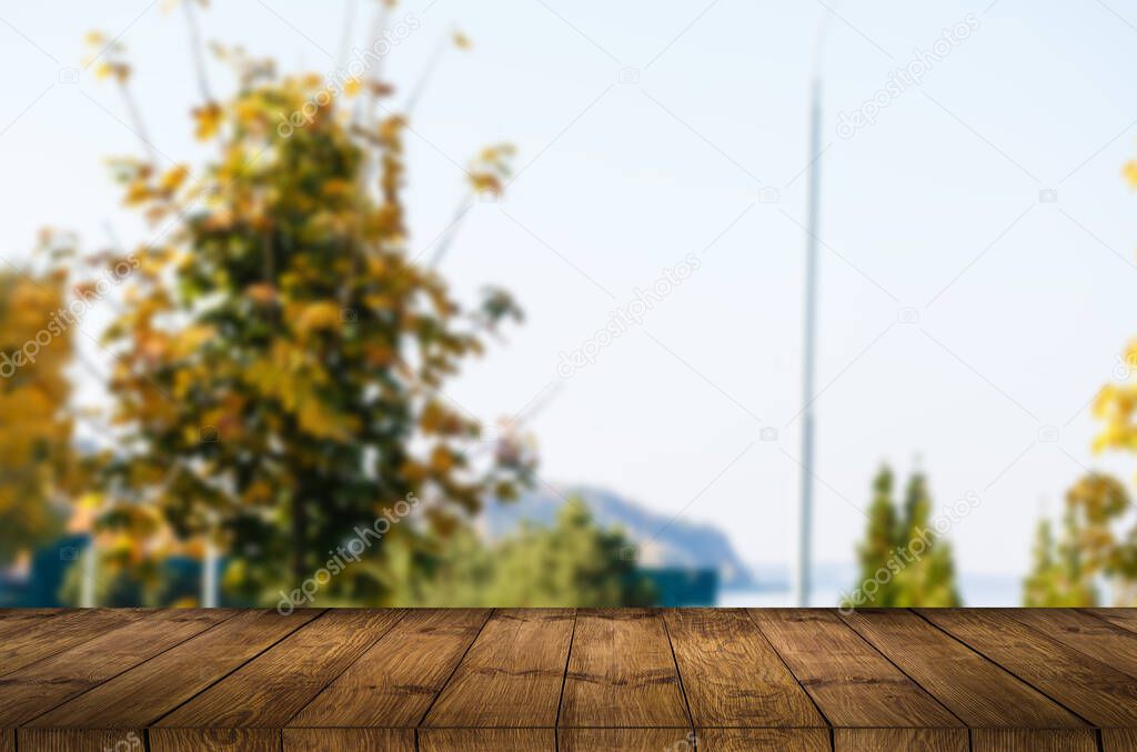 Empty wooden table with garden bokeh for a catering or food background with a country outdoor theme, mock up for display of product.