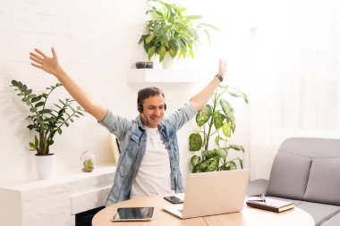 İnternette dizüstü bilgisayar kullanan yakışıklı bir genç.