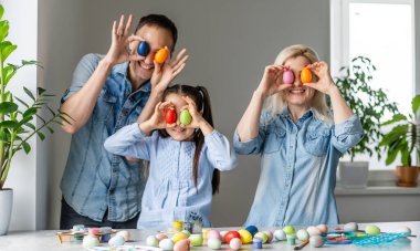 Paskalya yumurtalı mutlu bir aile. Mutlu aile Paskalya için hazırlanıyor.
