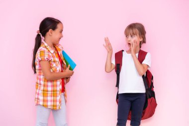 İki genç kız okulda fısıldıyor ve bir sırrı paylaşıyorlar.