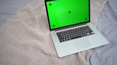 Yatağında yeşil ekran olan bir dizüstü bilgisayar. Uzak sanal uzaklık öğrenme video sohbetleri için kavram.