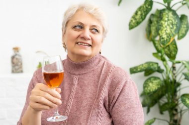 Şarabı yakından içen güzel, yaşlı bir kadın.