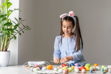 Boyanmış Paskalya Yumurtasını gösteren bir kız.