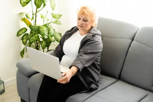 The elderly woman writes on the computer