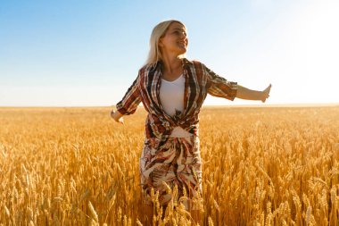 Buğday dikenlerinin ortasında bir kız. Kafkasyalı kadın dikenli çubuklarla dışarıda poz veriyor..