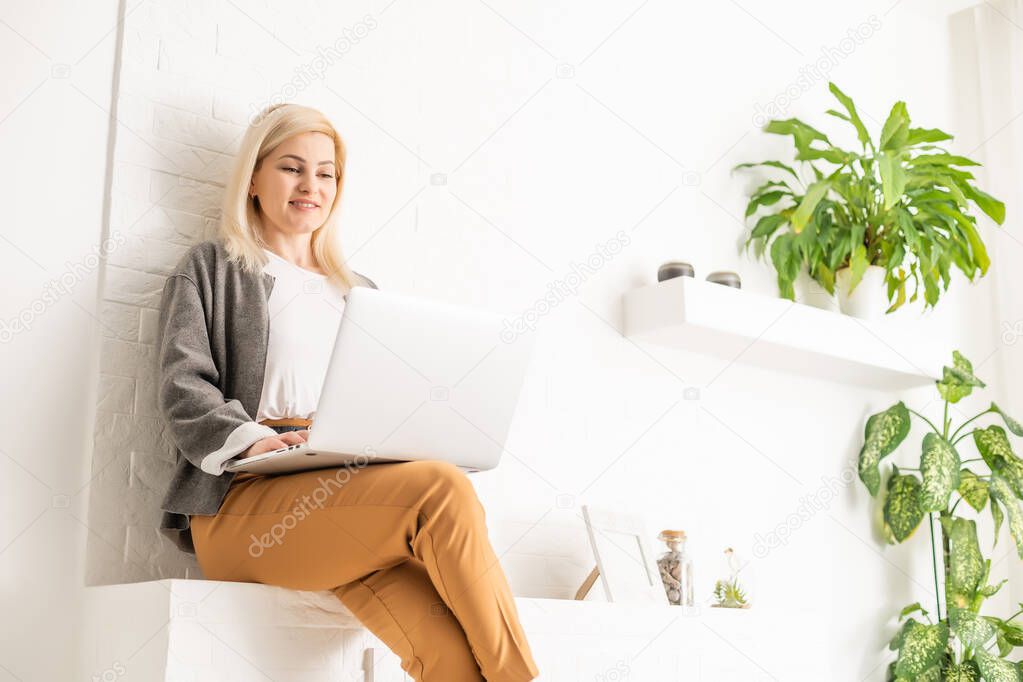 Cropped image of professional businesswoman working at her office via laptop, young female manager using portable computer device while sitting at modern loft, flare light, work process concept